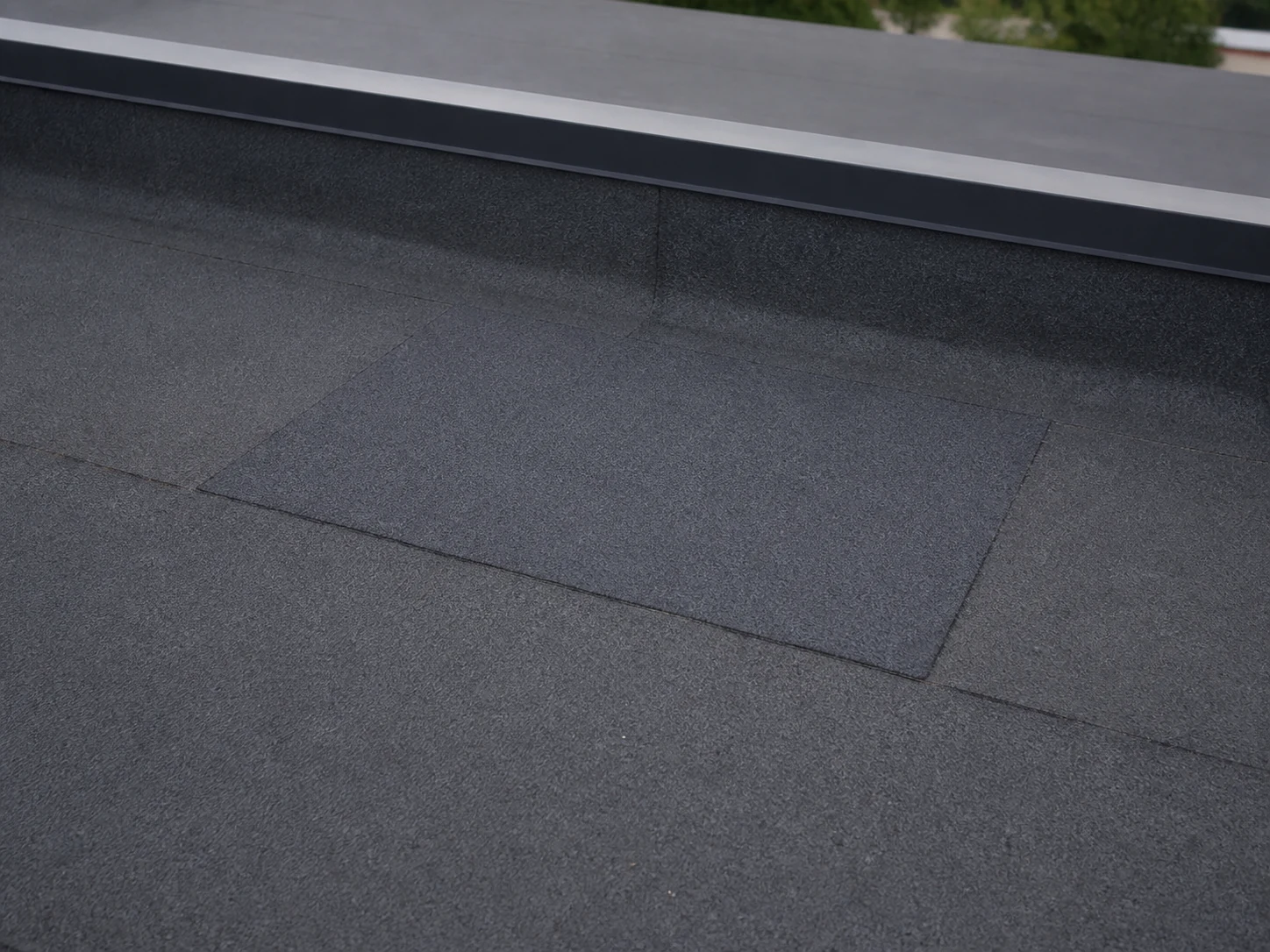 Neatly repaired patch on a felt flat roof