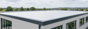 Finished light-coloured roof coating on a clean commercial flat roof